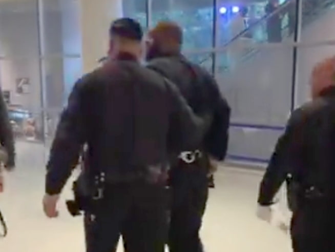 Image of Killer Mike being led in handcuffs by a police officer at the Crypto.com Arena.